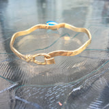 Worn Gold Tone Wavy Latch Bangle with Stone- Blue